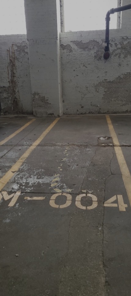 Private covered motorcycle parking spot with marked space